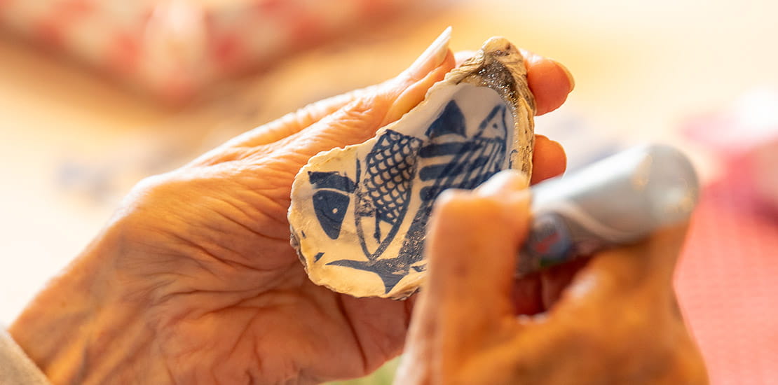 An oyster shell being decorated with glitter during a workshop with the Supercrafters